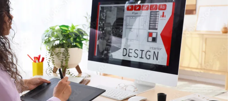 Person using a drawing tablet designing interior plans on a desktop monitor.
