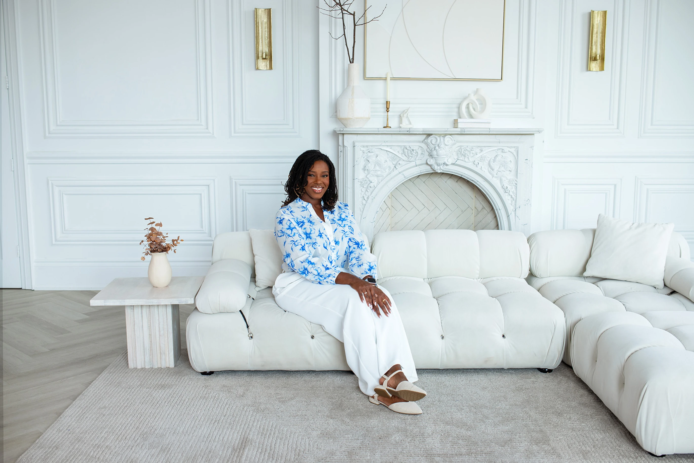 Shawnette Thompson of Talk2Me Therapy seated on a white sofa